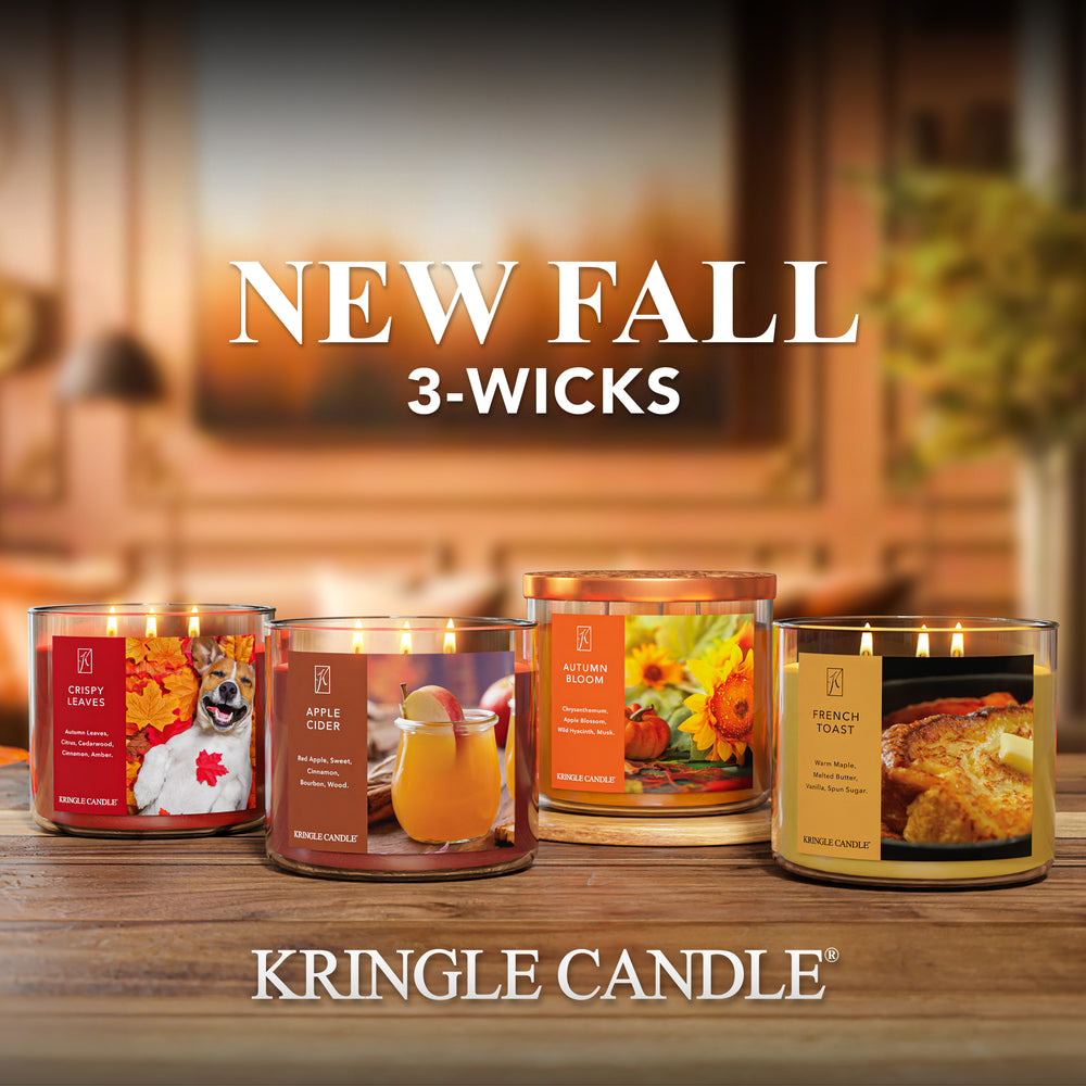 Kringle Candle fall-themed candles on a wooden surface with a blurred background