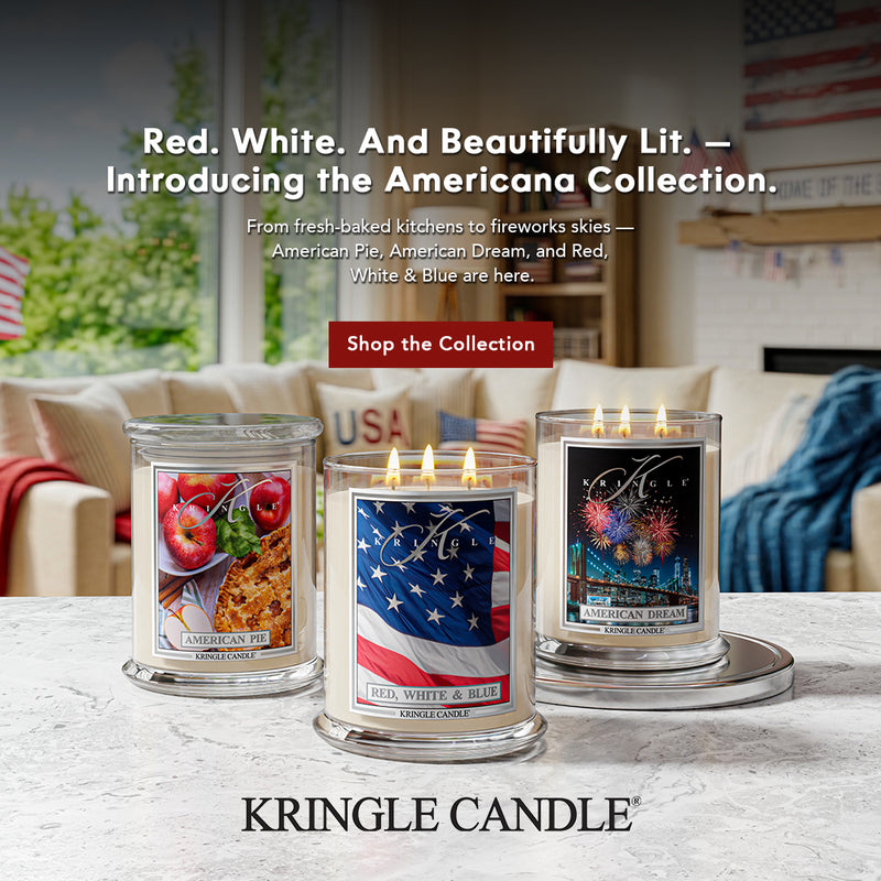 Three Kringle Candle scented candles on a table with a living room background, featuring American-themed designs.