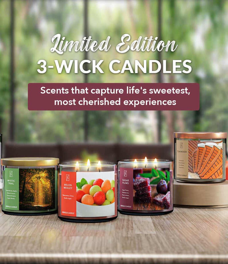 Four 3-wick candles on a wooden surface with a blurred natural background