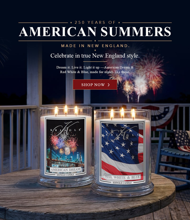 Kringle Candle American Dream and Red, White & Blue candles on a porch table with fireworks — 250 Years of American Summers, Shop Now