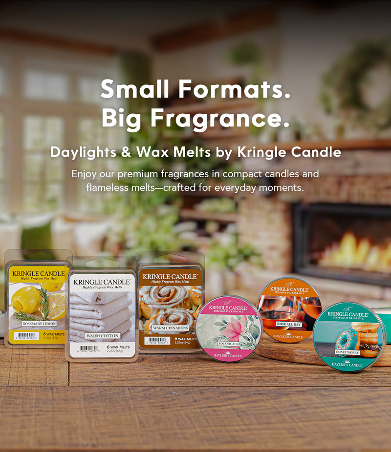 Kringle Candle wax melts and containers on a wooden surface with a fireplace in the background.