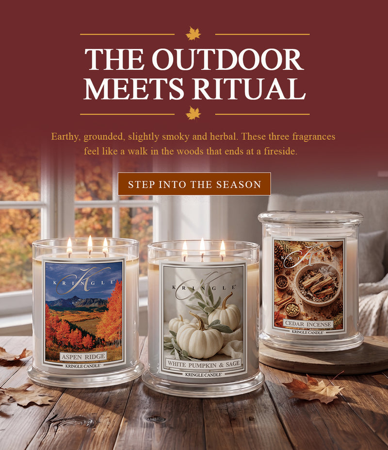 Kringle Candle fall banner featuring three 3-wick candles — Aspen Ridge, White Pumpkin & Sage, and Cedar Incense — displayed on a wooden table by a window with autumn foliage, with text 'The Outdoor Meets Ritual' and a 'Step Into the Season' button
