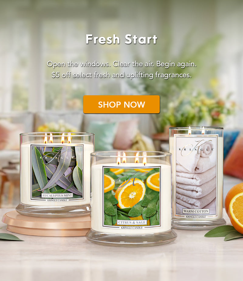 Three candles with labels on a table with a 'Fresh Start' text and 'Shop Now' button.