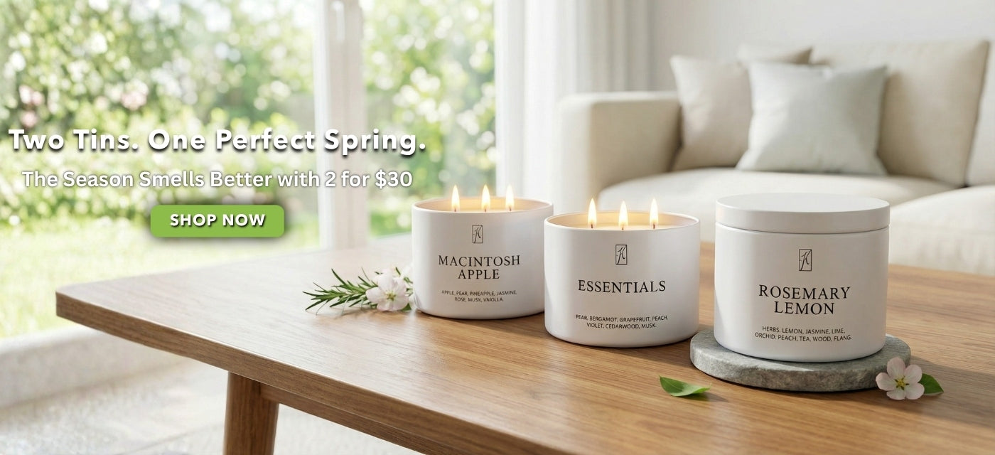 Three candles on a wooden table with a blurred background of a living room. Shop 2 for $30 tins.