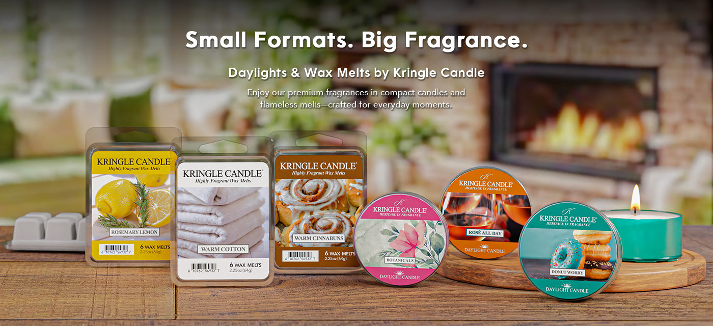 Kringle Candle products including tins and melts on a wooden surface with a fireplace in the background.