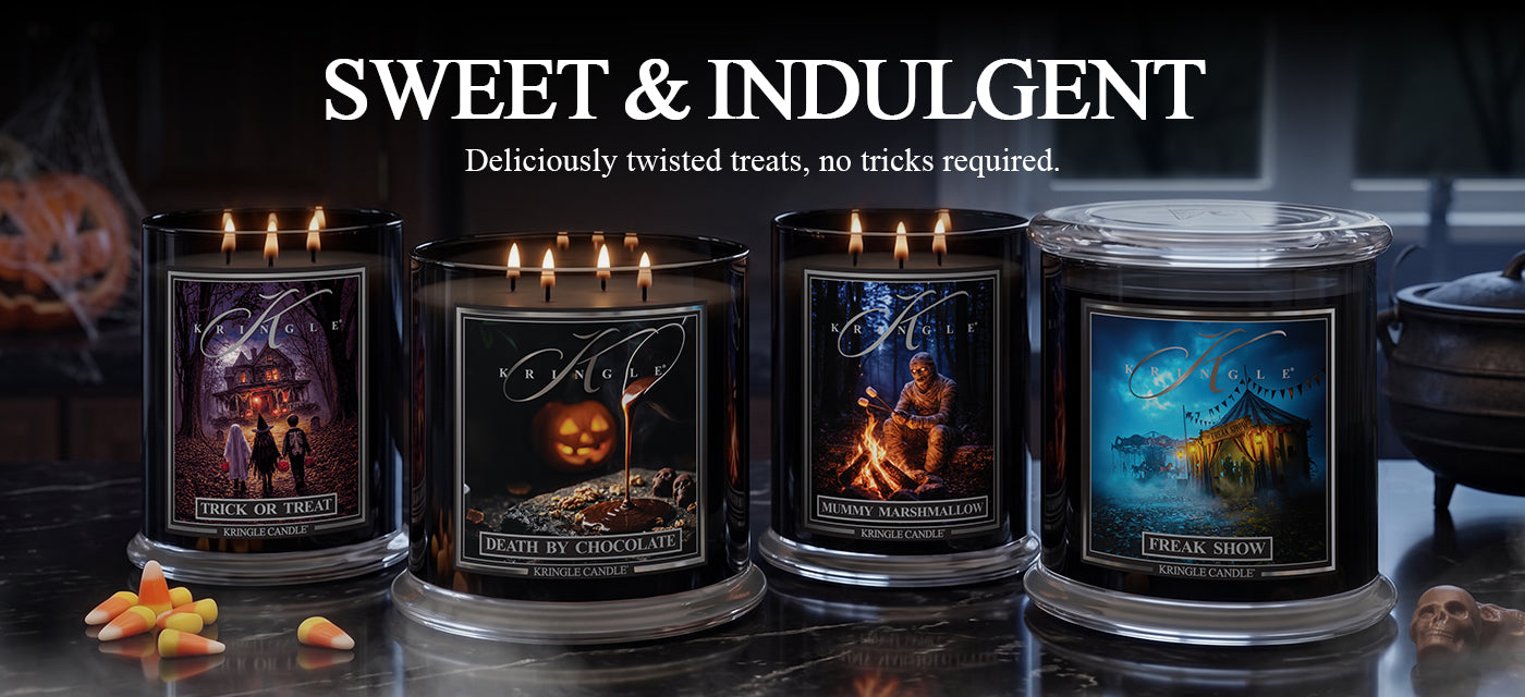 Four large Halloween-themed scented candles in black glass jars with silver bases, displayed on a dark reflective surface. The candles feature spooky illustrated labels including 'Crimson Bitch' with a witch, 'Grave Robbers' with a pumpkin, 'Cult Leader' with a campfire, and 'Lark Smith' under a blue moonlit sky.