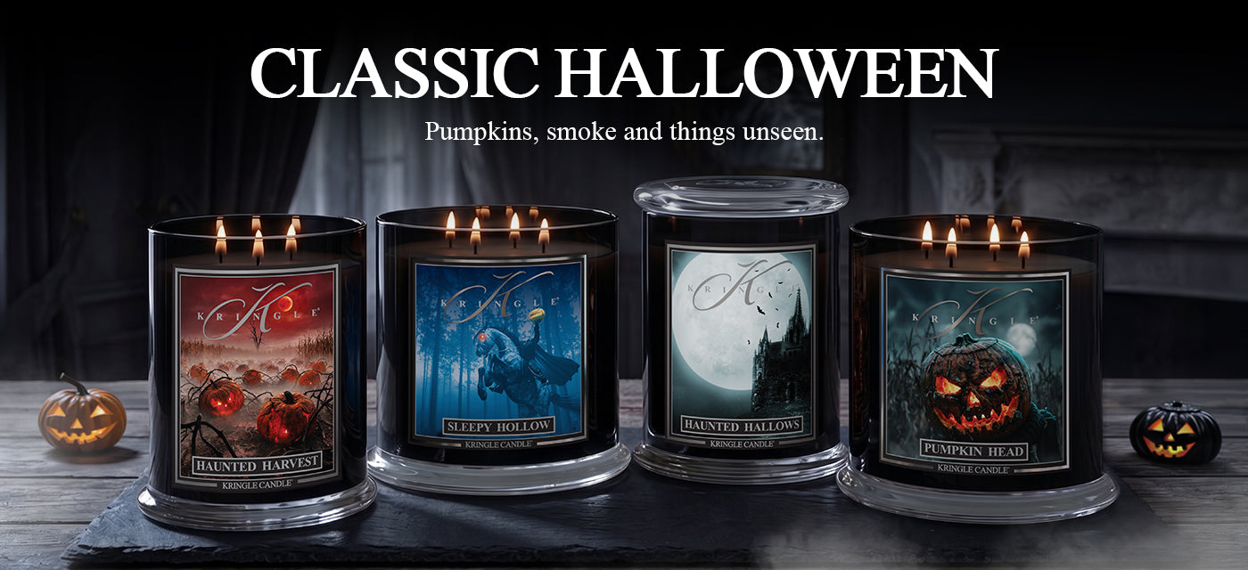 Four lit Halloween-themed candles in black glass jars are displayed on a dark tabletop with pumpkins on both sides. Large text at the top reads 'CLASSIC HALLOWEEN' with the tagline 'Pumpkins, smoke and things unseen.