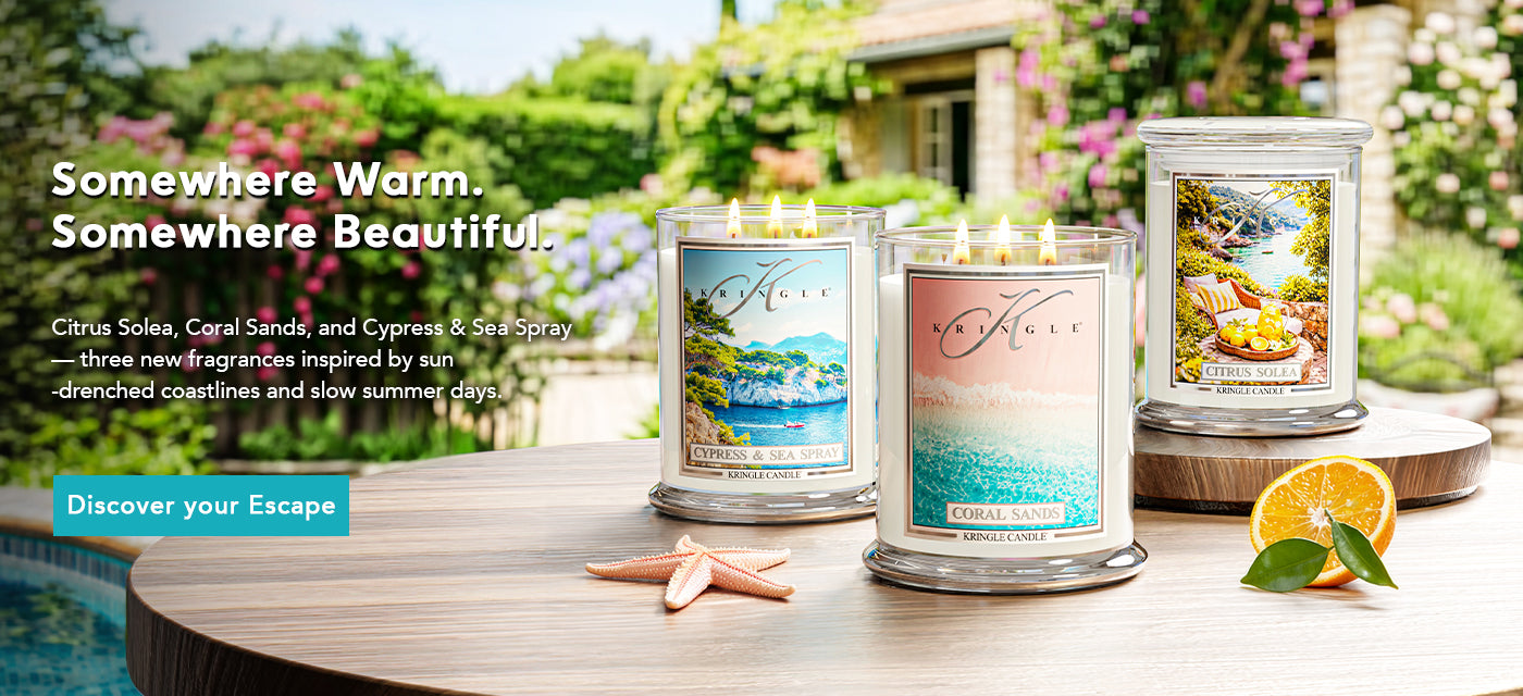 Three candles on a table with scenic packaging in a garden setting.