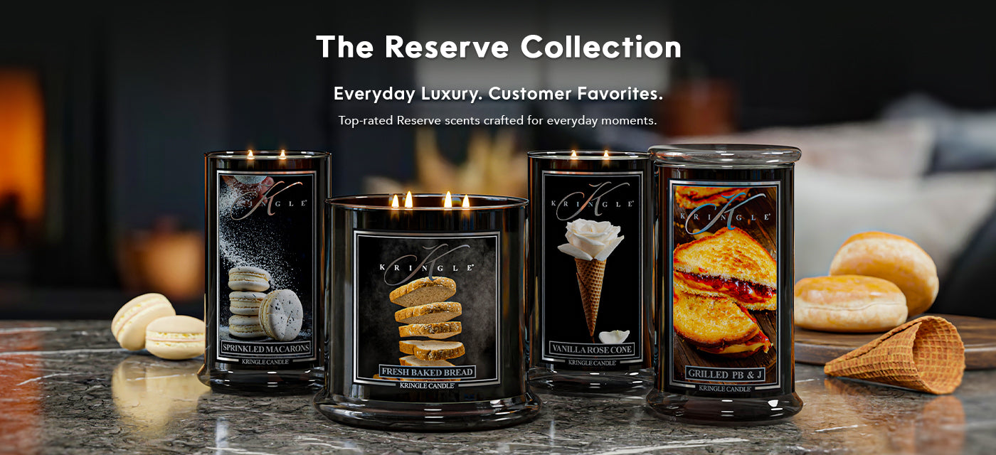 Four candles from The Reserve Collection on a table with a blurred background