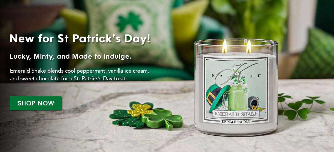 Sculptured candle with St. Patrick's Day design on a marble surface with shamrock leaves.