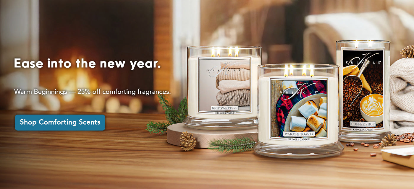 Three candles on a wooden surface with a fireplace in the background, featuring text about new year's scents.