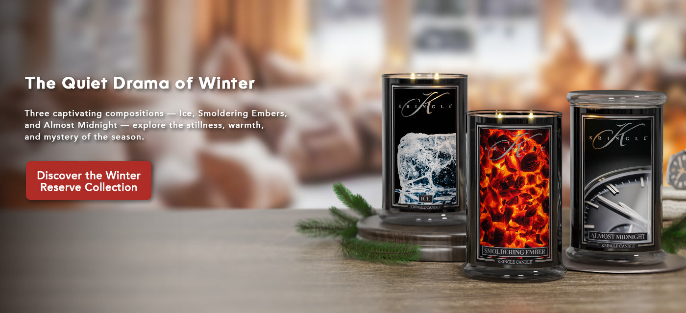 Three candles from the Winter Reserve Collection on a wooden surface with decorative elements.
