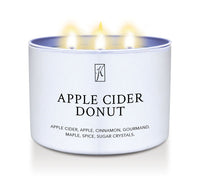 Candle in a white container labeled 'Apple Cider Donut' with flames on a white background