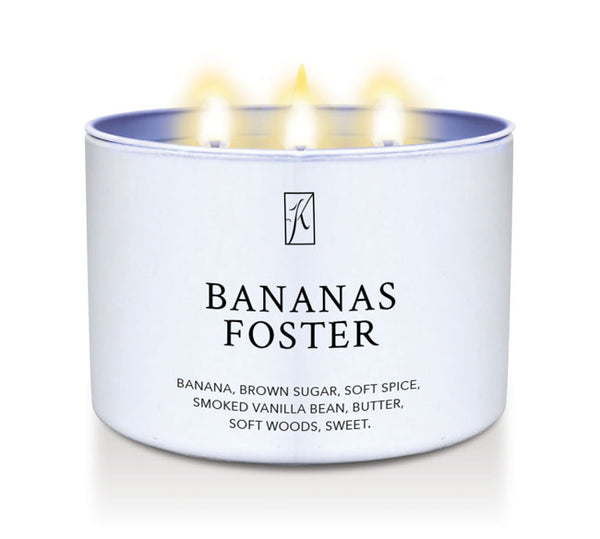 Candle in a container labeled 'Bananas Foster' with a logo on a white background