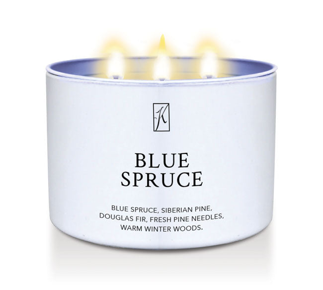 Candle in a white container labeled 'Blue Spruce' with flames on a white background