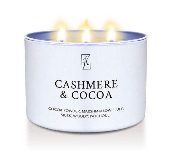 Candle in a white container labeled 'Cashmere & Cocoa' with flames on a white background