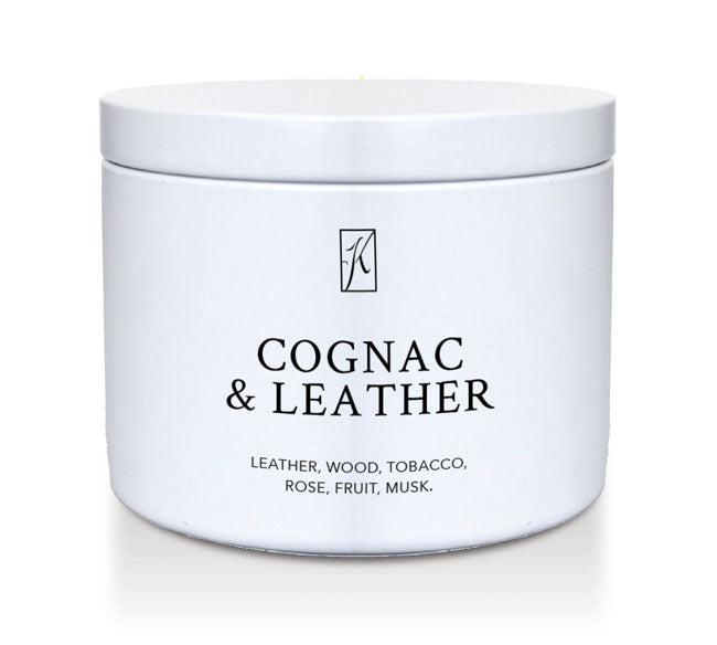 White candle tin container of 'Cognac & Leather' fragrance on a white background