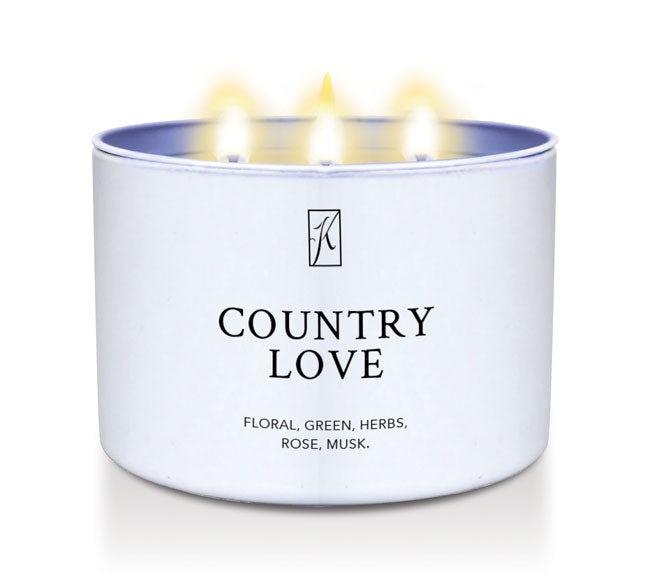 Candle in a white tin container labeled 'Country Love' with 3 wick flames on a white background