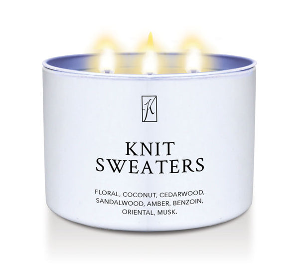 Candle in a white container labeled 'Knit Sweaters' with flames on a white background