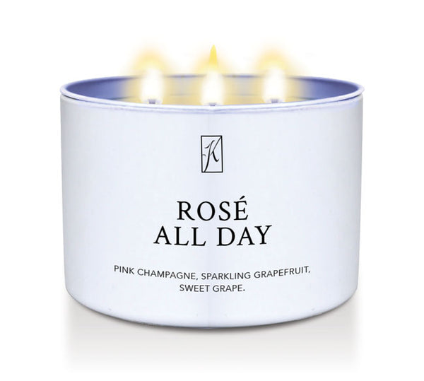 Candle in a white container labeled 'Rosé All Day' with flames on a white background