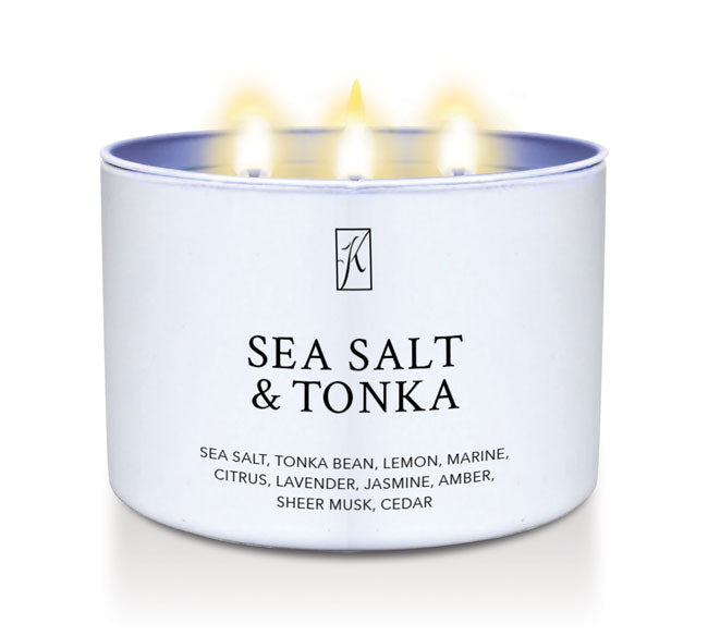 'Sea Salt & Tonka' scented candle in a tin container with 3 wicks with flames on a white background by Kringle Candle
