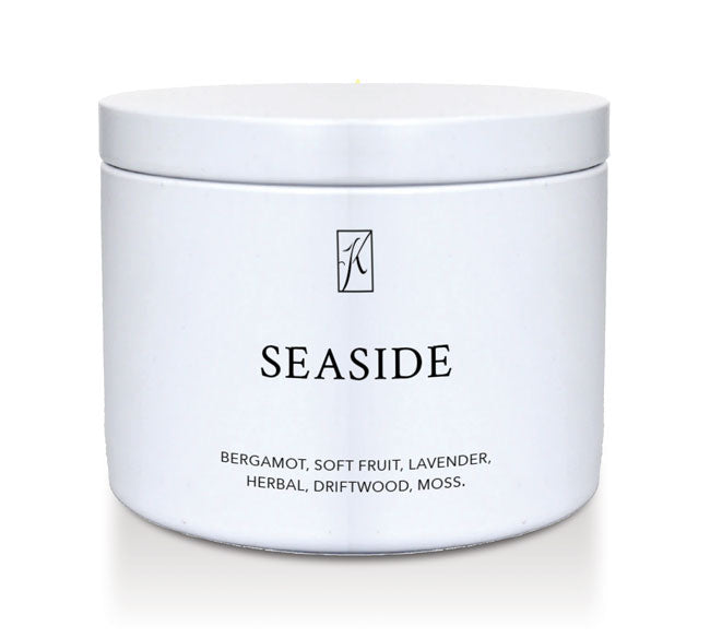 White tin candle container labeled 'Seaside' with a brand logo on a white background