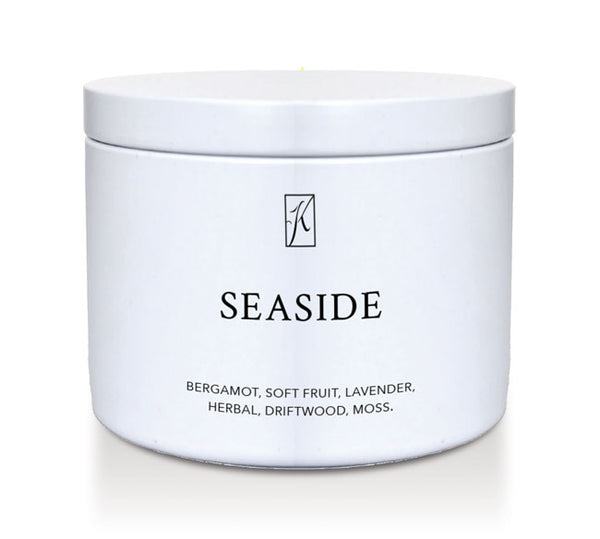 White tin candle container labeled 'Seaside' with a brand logo on a white background