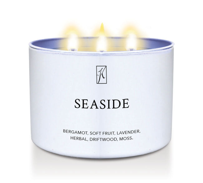 White tin candle container labeled 'Seaside' with a brand logo on a white background