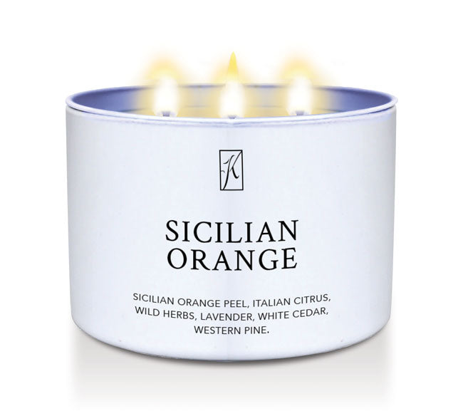 Candle in a white tin container labeled 'Sicilian Orange' on a white background