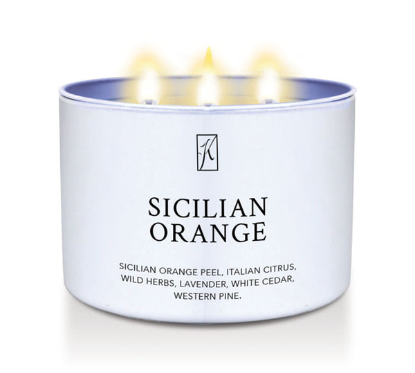 Candle in a white tin container labeled 'Sicilian Orange' on a white background