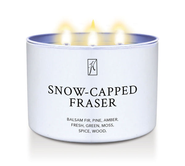 Candle in a white tin container labeled 'Snow-Capped Fraser' with flames on a white background