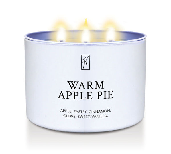 Candle in a white container labeled 'Warm Apple Pie' with a logo on a white background