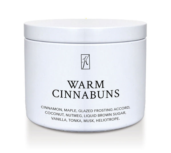 Jar of candle labeled 'Warm Cinnabuns' with a brand logo on a white background