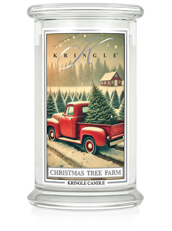"Kringle Candle large jar featuring a red truck and snowy Christmas tree farm with a cozy cabin in the background."