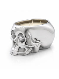 A metallic silver skull-shaped candle holder with three wicks, filled with cream-colored wax, set against a clean white background.