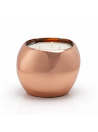 A three-wick candle in a rounded, polished copper-colored metallic holder, set against a clean white background.
