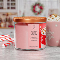 Pink Kringle Candle with a Christmas theme and a blurred festive background.