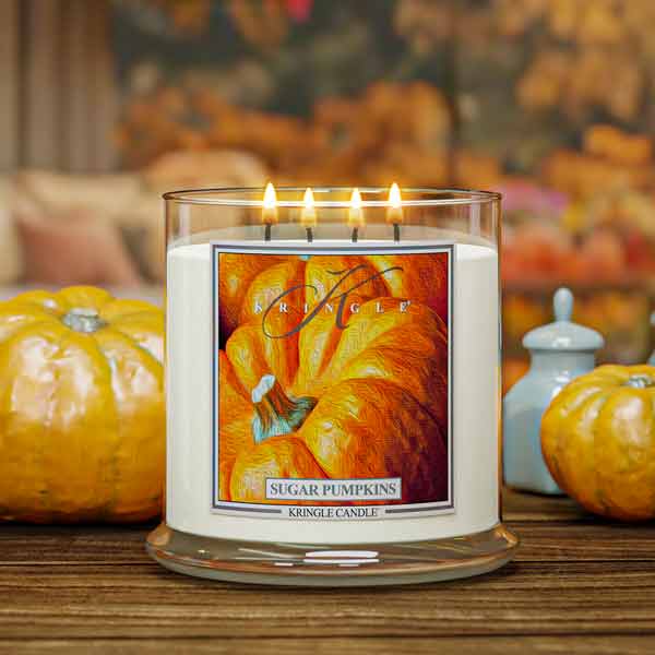 Kringle Candle with 'Sugar Pumpkins' label on a wooden surface with pumpkins in the background