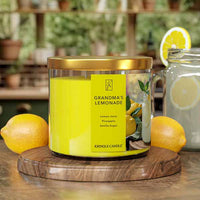 Kringle Candle 'Grandma's Lemonade' candle on a wooden coaster with lemons and a blurred kitchen background.