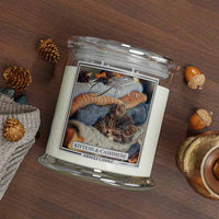 Kringle Candle jar with a kitten and cashmere 4-wick candle with cat label on a wooden surface with decorative elements.
