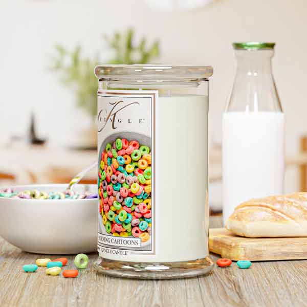 Candle with a colorful label on a table with cereal, milk, and bread.