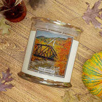 Kringle CandleRail RAIL Bridge 4-wick scented candle on a wooden surface with decorative elements