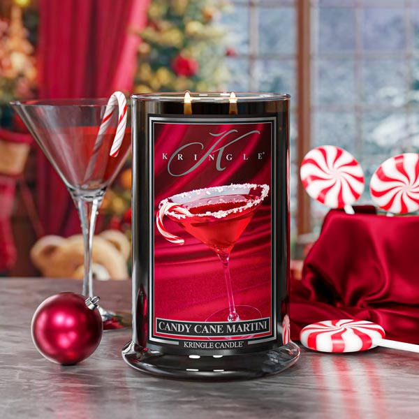 Kringle Candle in a decorative container with Christmas-themed elements on a table.