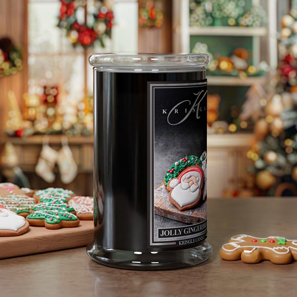 Black candle jar with a festive label on a table with Christmas cookies