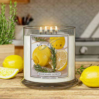 Lit Kringle Candle 4-wick  in Rosemary Lemon scent with glowing flames and label showing lemons and rosemary with lifestyle kitchen background.