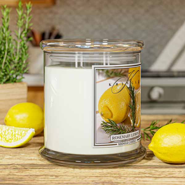 Lit Kringle Candle 4-wick  in Rosemary Lemon scent and label showing lemons and rosemary with lifestyle kitchen background.