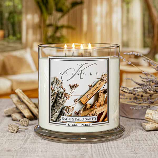 Kringle Candle with 'Sage & Palo Santo' label on a table with decorative elements.