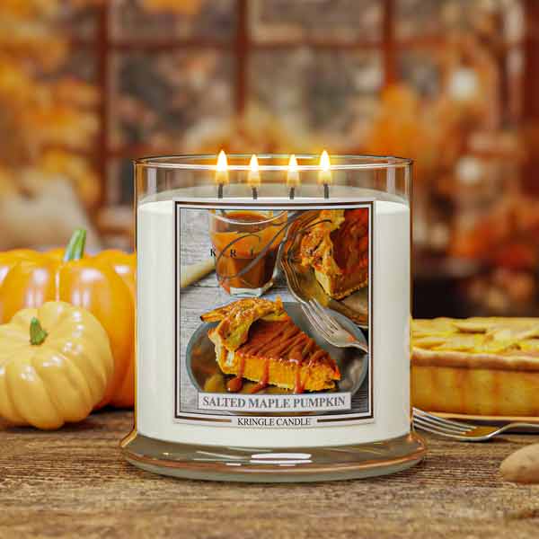 Salted Maple Pumpkin Candle with a pumpkin pie design on the label, surrounded by pumpkins and pie in the background.