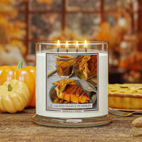 Salted Maple Pumpkin Candle with a pumpkin pie design on the label, surrounded by pumpkins and pie in the background.