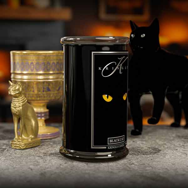 Black candle with 'Kringle Candle' branding and a black cat in the background